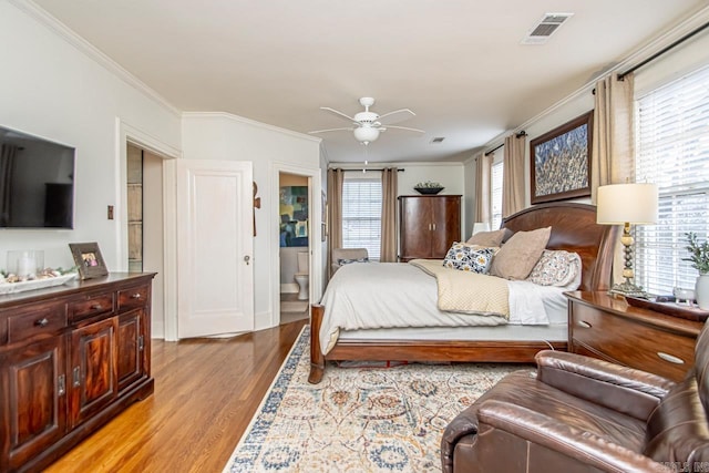 bedroom featuring visible vents, multiple windows, crown molding, and light wood-type flooring