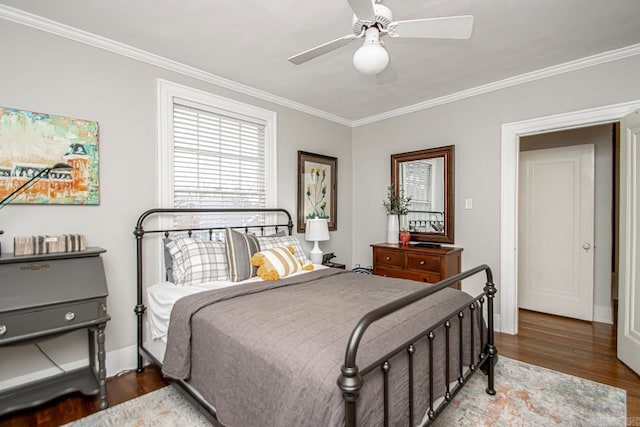 bedroom with ceiling fan, baseboards, wood finished floors, and crown molding