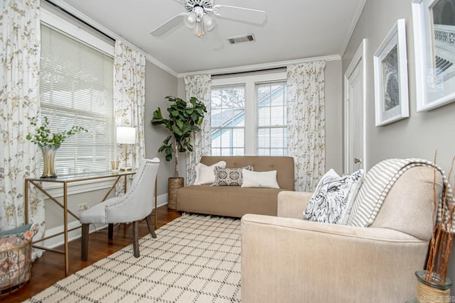 interior space with visible vents, crown molding, baseboards, ceiling fan, and wood finished floors