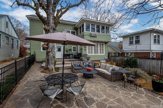 rear view of house with a patio area, an outdoor living space with a fire pit, and a fenced backyard