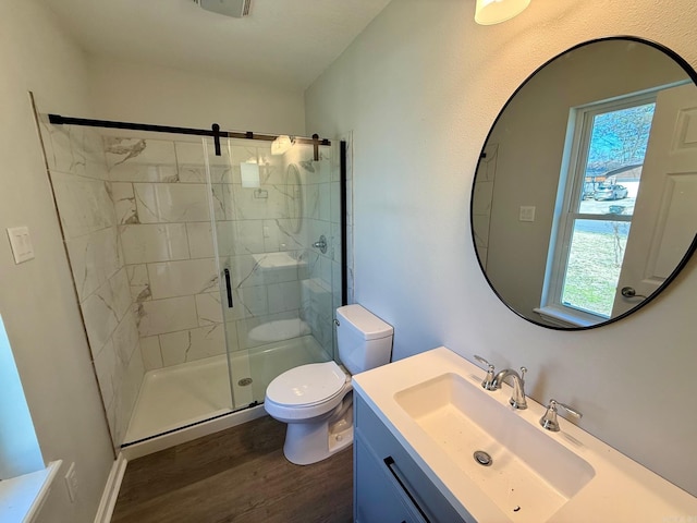 bathroom featuring a healthy amount of sunlight, a stall shower, toilet, and wood finished floors