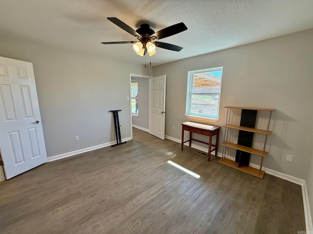 unfurnished bedroom featuring visible vents, ceiling fan, baseboards, wood finished floors, and a textured ceiling