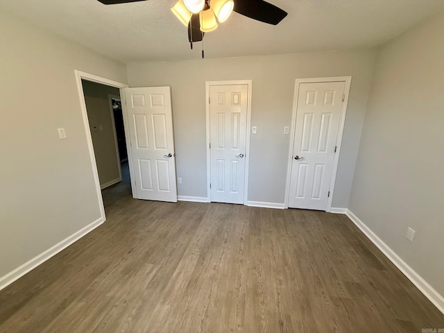 unfurnished bedroom with dark wood finished floors and baseboards