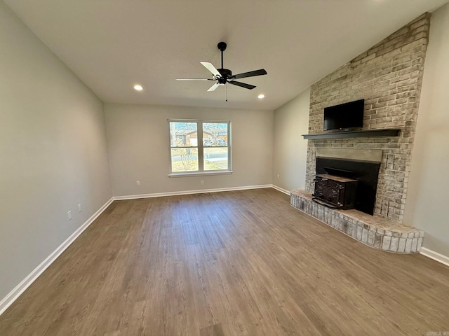 unfurnished living room featuring baseboards, wood finished floors, a ceiling fan, and vaulted ceiling