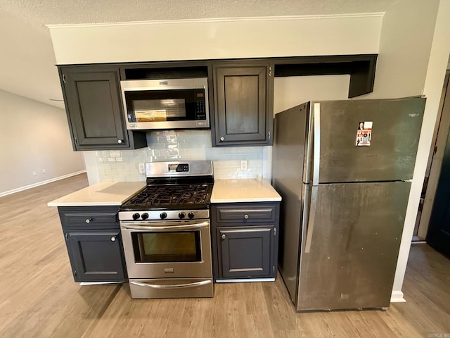 kitchen with backsplash, light wood-style flooring, and stainless steel appliances