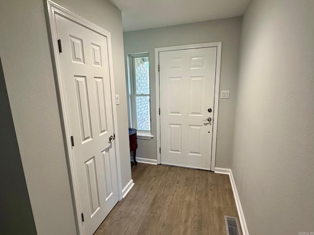 doorway featuring visible vents, baseboards, and dark wood-style floors