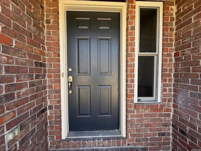 doorway to property with brick siding