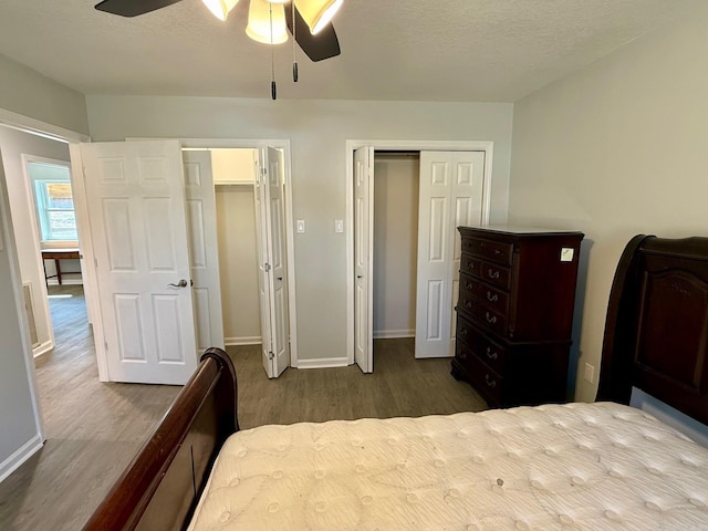 bedroom with ceiling fan, baseboards, a textured ceiling, and wood finished floors