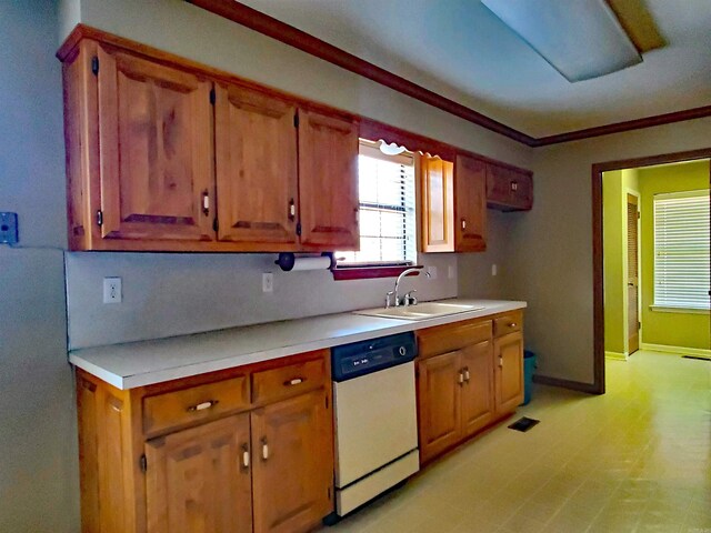 kitchen featuring baseboards, a sink, light countertops, dishwasher, and crown molding