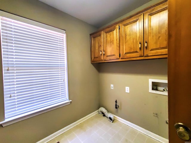 washroom with a wealth of natural light, baseboards, cabinet space, and washer hookup