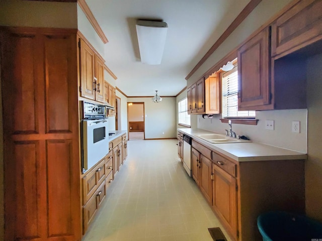 kitchen with visible vents, crown molding, light countertops, white appliances, and a sink