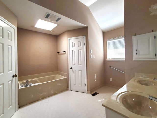 bathroom featuring a sink, visible vents, a garden tub, and double vanity