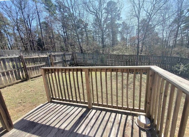 wooden terrace featuring a lawn and a fenced backyard