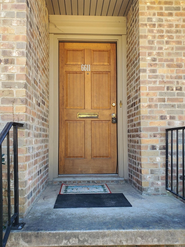 view of exterior entry featuring brick siding