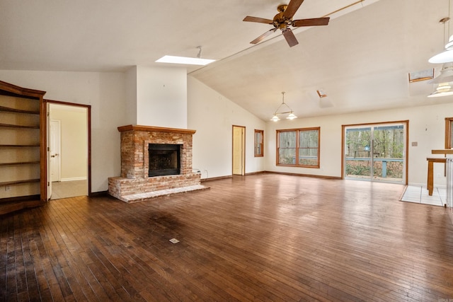 unfurnished living room with a brick fireplace, baseboards, hardwood / wood-style floors, high vaulted ceiling, and a ceiling fan