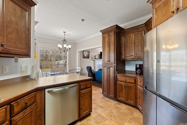 kitchen featuring pendant lighting, stainless steel appliances, a peninsula, crown molding, and a chandelier