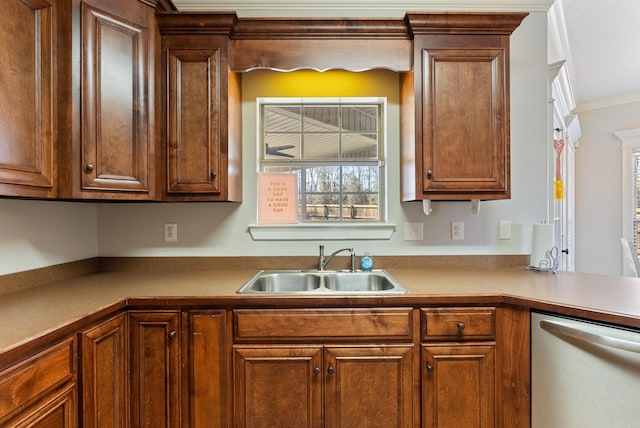 kitchen with brown cabinets, ornamental molding, a sink, stainless steel dishwasher, and light countertops