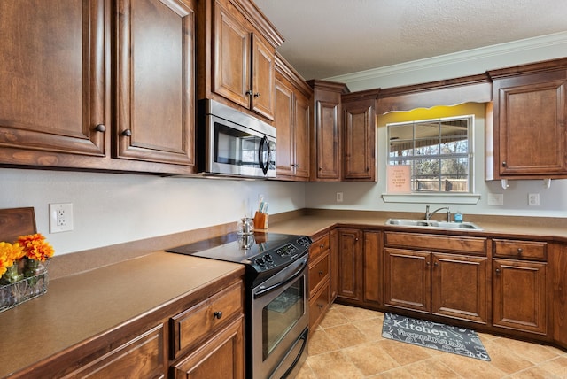 kitchen with ornamental molding, a sink, a textured ceiling, stainless steel appliances, and light tile patterned flooring