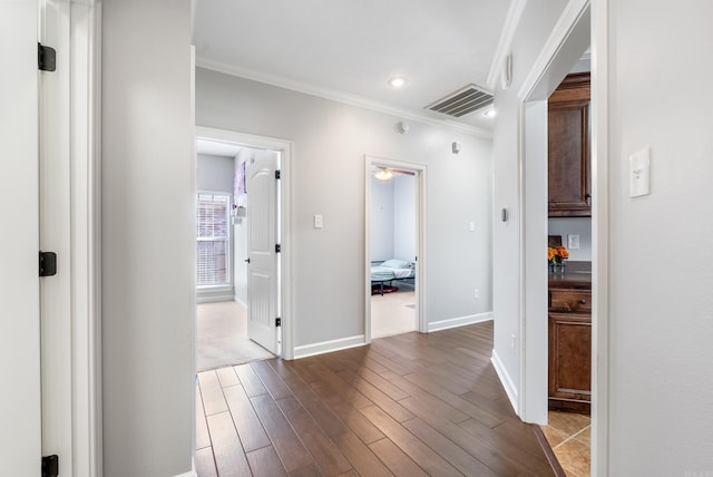 hallway with visible vents, baseboards, ornamental molding, recessed lighting, and wood finished floors