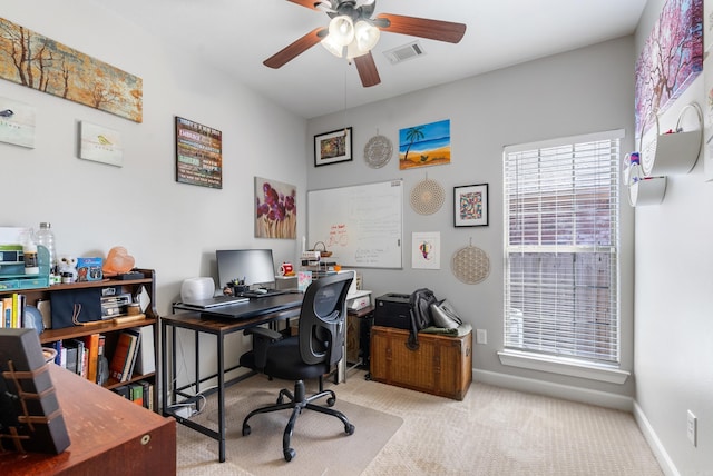 carpeted home office with a ceiling fan, visible vents, and baseboards