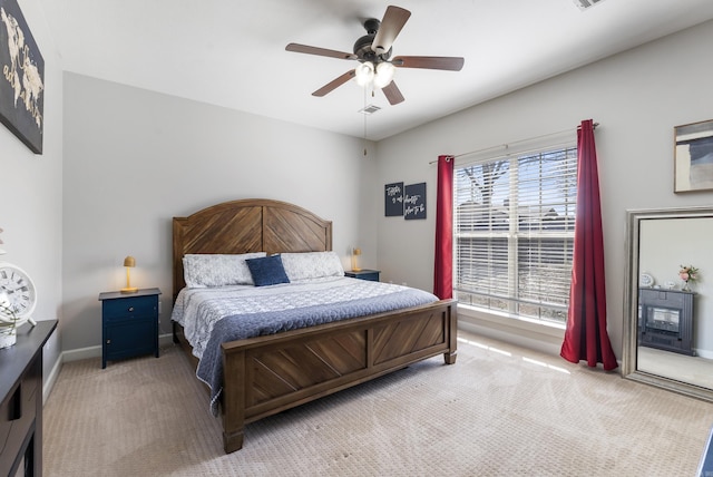 bedroom featuring light carpet, visible vents, a ceiling fan, and baseboards