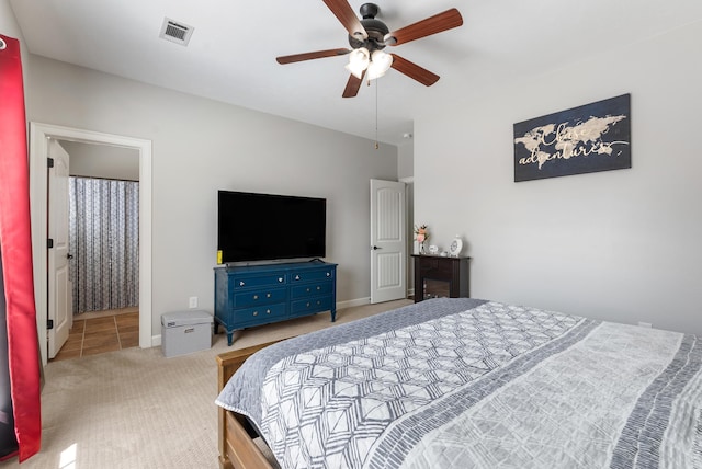 carpeted bedroom featuring a ceiling fan, visible vents, and baseboards