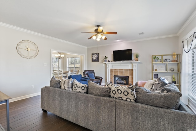 living area featuring dark wood-style floors, baseboards, visible vents, a tile fireplace, and crown molding