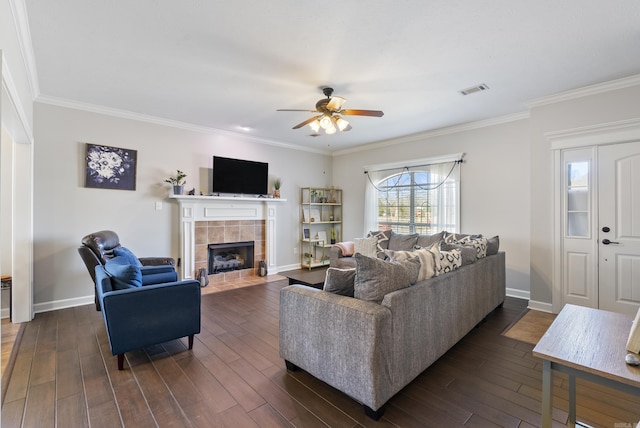 living area with visible vents, dark wood finished floors, a fireplace, crown molding, and baseboards