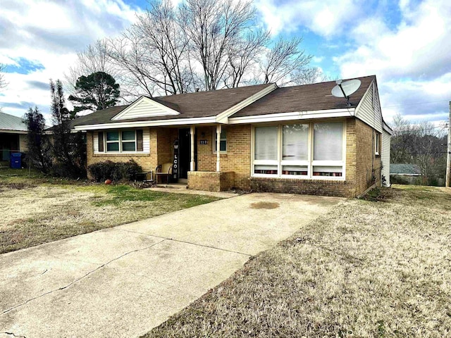 ranch-style house featuring brick siding and a front yard