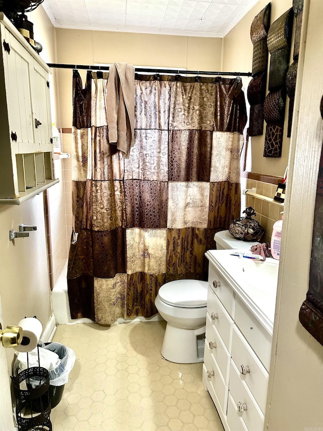 bathroom with toilet, tile walls, vanity, and shower / tub combo