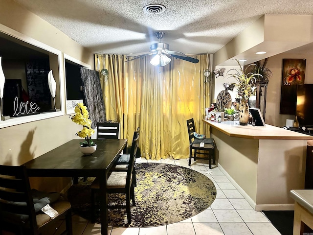 dining room featuring visible vents, a textured ceiling, a ceiling fan, and tile patterned flooring