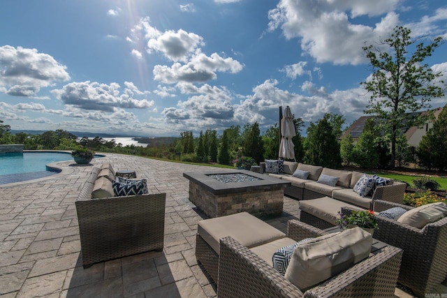 view of patio featuring an outdoor pool and an outdoor living space with a fire pit