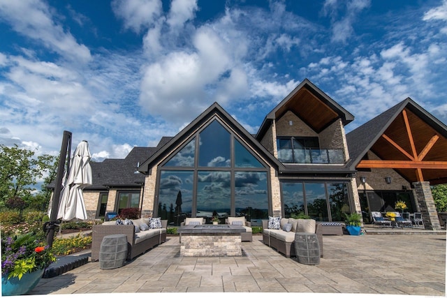 rear view of house with an outdoor living space with a fire pit, a patio area, and brick siding