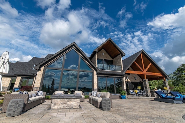 exterior space featuring an outdoor living space with a fire pit and a patio