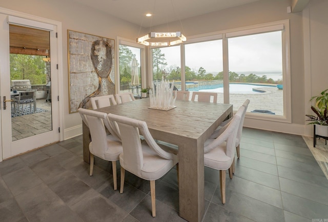 dining room featuring a wealth of natural light, baseboards, and dark tile patterned floors