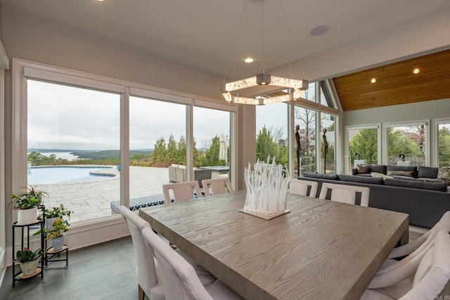 tiled dining room with recessed lighting, wood ceiling, a water view, and vaulted ceiling