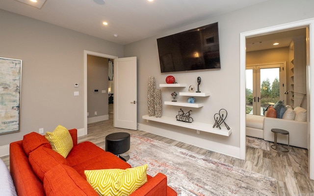 living room with french doors, light wood-type flooring, and baseboards