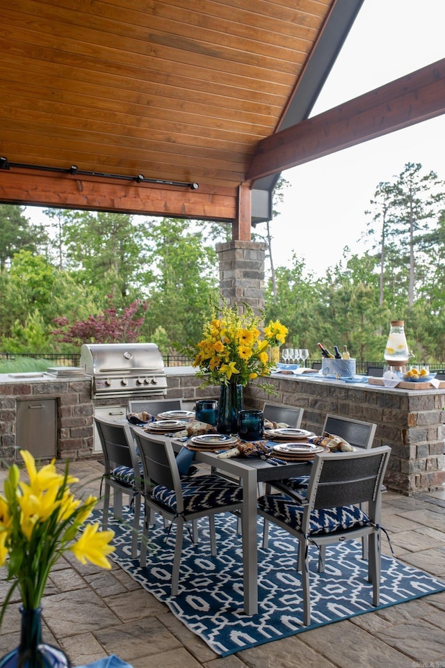 view of patio featuring area for grilling, outdoor dining area, and a grill