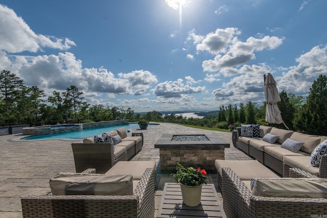 view of swimming pool with an outdoor living space with a fire pit, a patio area, and a pool with connected hot tub