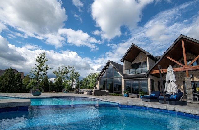 view of pool with a patio area, an outdoor living space, and a pool with connected hot tub