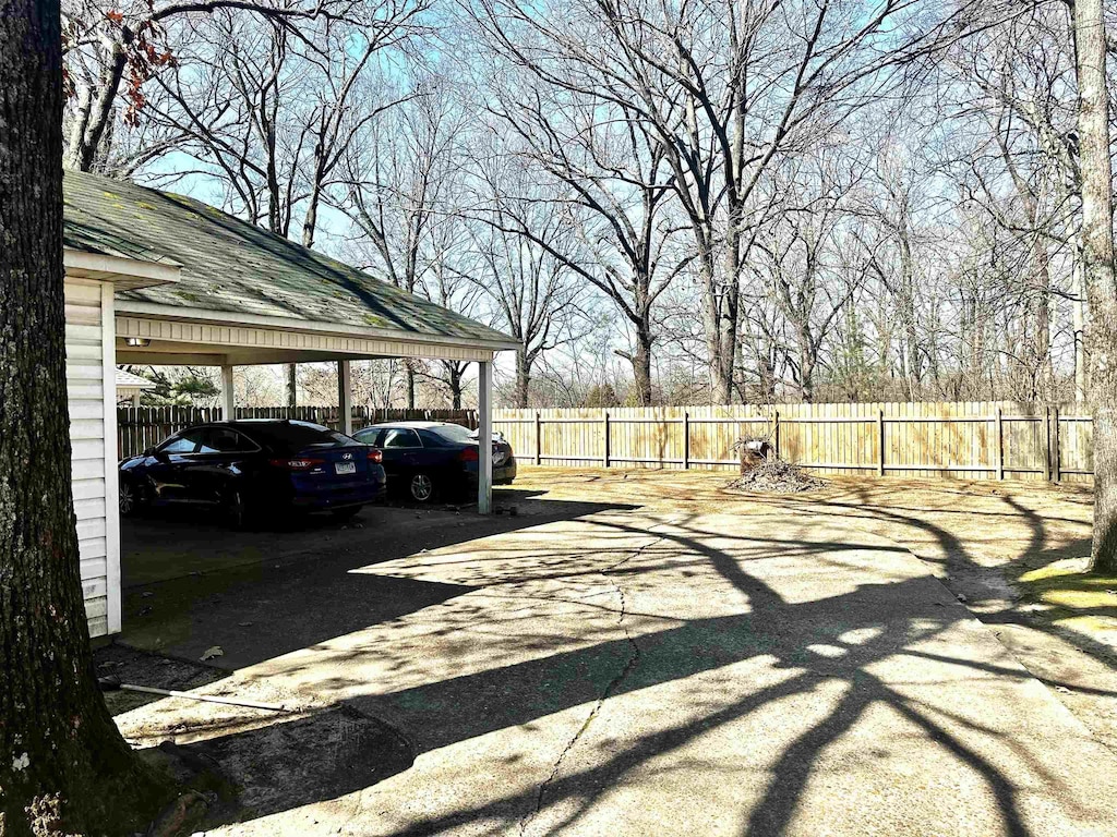 view of vehicle parking with fence