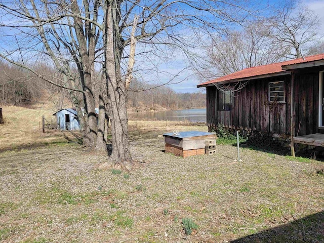 view of yard featuring a water view and an outbuilding