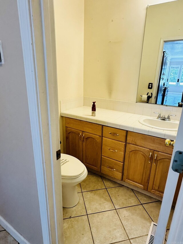 bathroom featuring vanity, tile patterned floors, and toilet