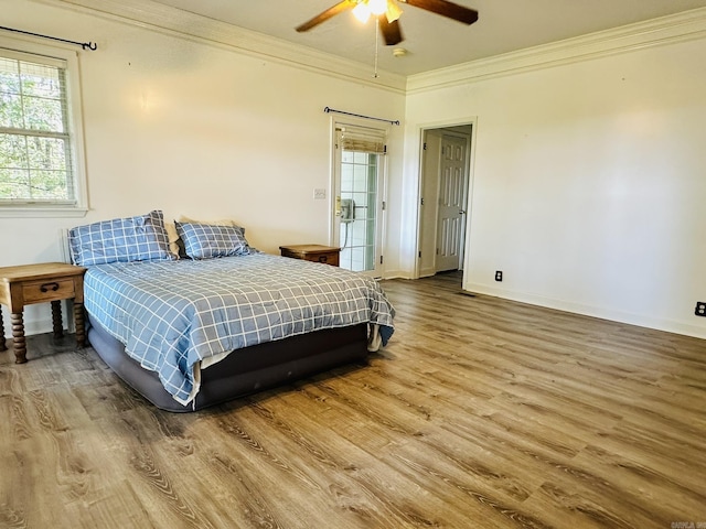 bedroom with ceiling fan, baseboards, wood finished floors, and crown molding