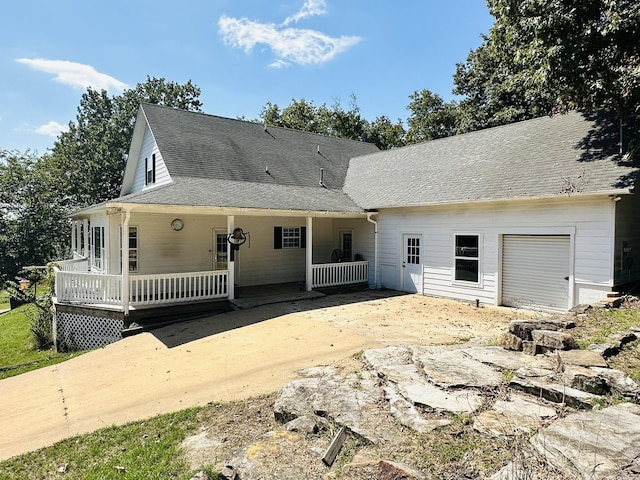 rear view of property featuring a shingled roof