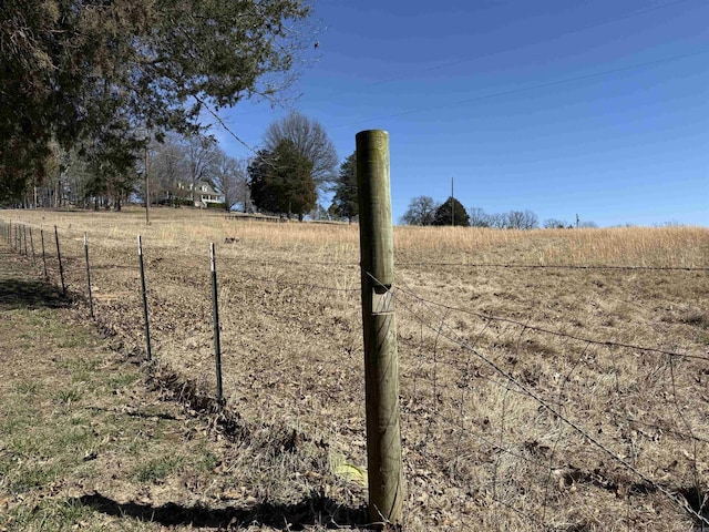 view of yard featuring a rural view and fence