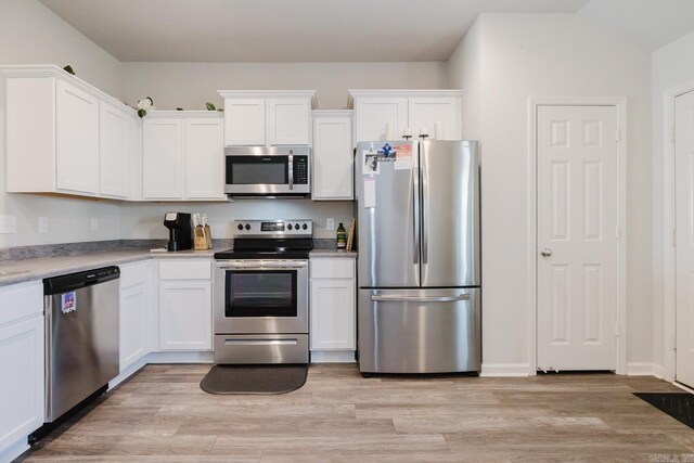 kitchen with light wood-style floors, appliances with stainless steel finishes, and white cabinetry