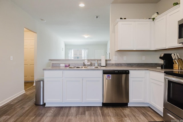 kitchen with white cabinets, dark wood-style floors, appliances with stainless steel finishes, and a sink