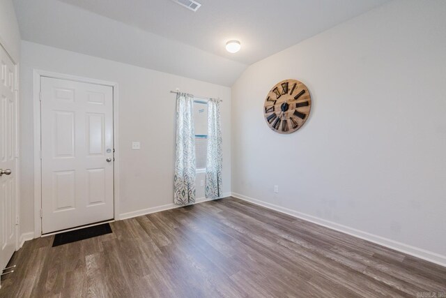 interior space with lofted ceiling, baseboards, and wood finished floors