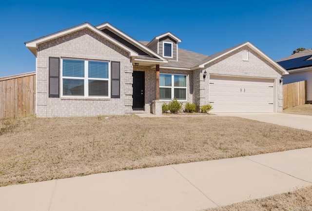 view of front of property featuring driveway, brick siding, an attached garage, and fence